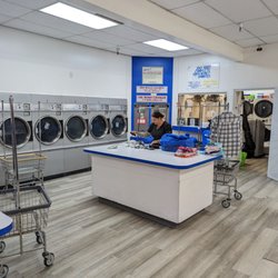Mission Plaza Laundromat - Rosie, owner/manager working folding customer clothes.