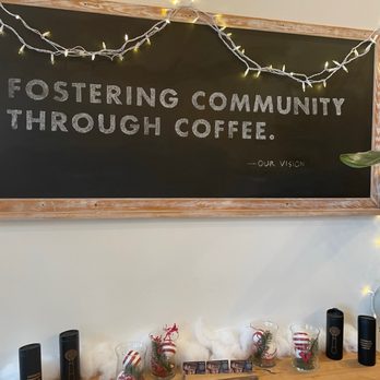 Foster Coffee Company - a chalkboard with a sign that reads fostering community through coffee - Coffee & Tea Near Me - Owosso, Michigan