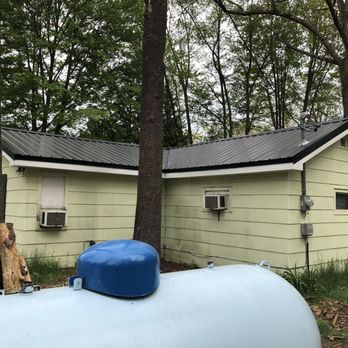 Integral Builders - a house with a water tank in front of it - Roofing Near Me - Clare, Michigan