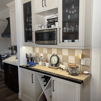 Rock on Renovations - a kitchen with white cabinets and black countertops - Flooring Near Me Rock on Renovations - a kitchen with white cabinets and black countertops - Flooring Near Me