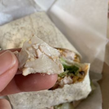 The Local Deli - a hand holding a chicken wrap - Delis Near Me - Rathdrum, Idaho