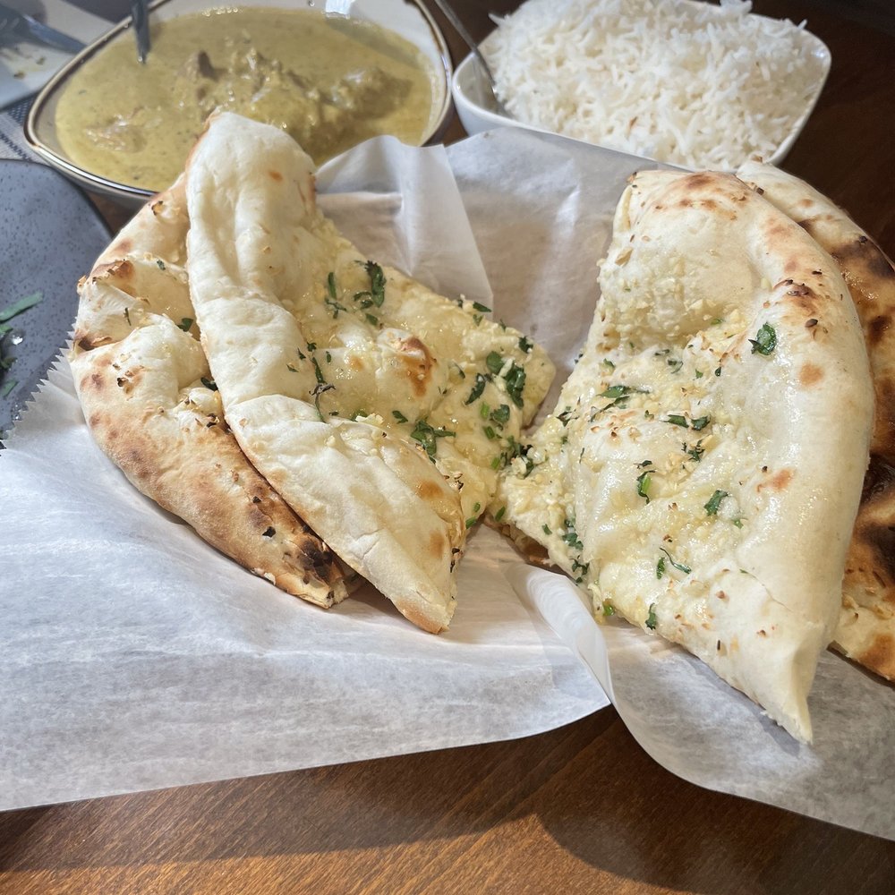 Athithi Indian Cuisine - Garlic naan,  pistachio chicken and rice in the back - Indian Near Me - Wilton, Connecticut