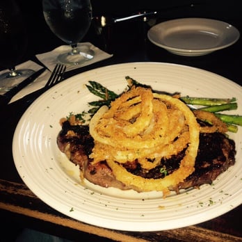 Fire Creek - Cajun ribeye topped with fried onion rings and asparagus - American Near Me - West des Moines, Iowa
