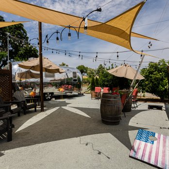 Scribner Bend Vineyards - patio area with chairs and umbrellas - Venues & Event Spaces Near Me - Sacramento, California