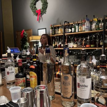 Space - a woman standing behind a bar filled with bottles of alcohol - Performing Arts Near Me - Evanston, Illinois
