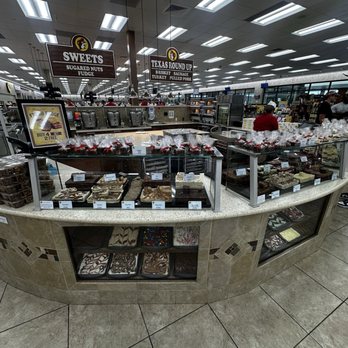 Buc-ee’s - Fudge Counter - A fudge counter at Buc-ee's in Saint Augustine, FL, features an assortment of chocolates, baked goods, and candy, with signs indicating different food sections. - Gas Stations Near Me - Saint Augustine, Florida