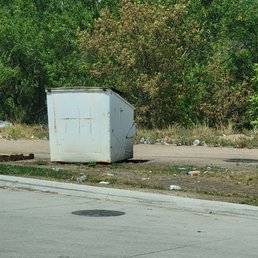 a trash dumpster on the side of the road a trash dumpster on the side of the road