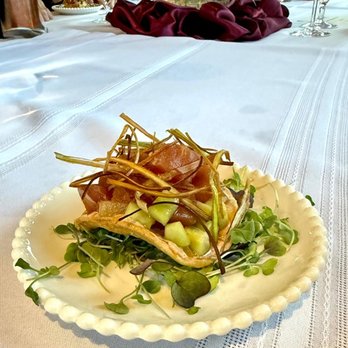 Pairing Project - A dish featuring greens, diced vegetables, and crispy garnishes is presented on a white, scalloped-edged plate at a formal dining event. - Personal Chefs Near Me - Austin, Texas