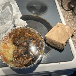 Jerk chicken and oxtail platter with beans and rice and veggies.
