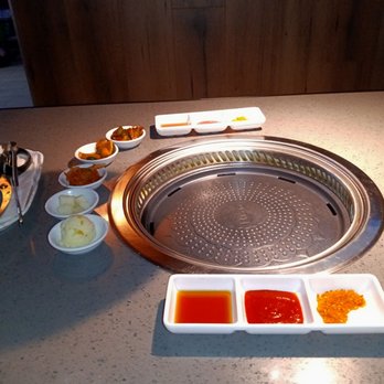 Volcano Korean BBQ - Before I ordered, all this was laid out in front of me. Side dishes to the left and dipping sauces in the front. - Korean Near Me - Amarillo, Texas