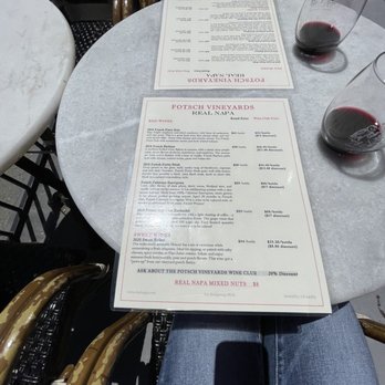 Real Napa - a person sitting at a table with a menu - Wine Tasting Room Near Me - Sausalito, California