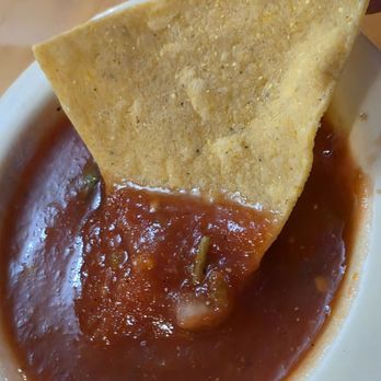 Los Arcos - A Chip being dipped in the Salsa which was a bit hot, and no mild one around. - Mexican Near Me - Roanoke, Virginia