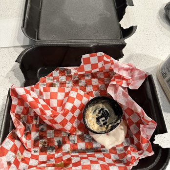 Main Bird Hot Chicken - Cypress - a half eaten sandwich in a container - Chicken Shop Near Me - Cypress, Texas