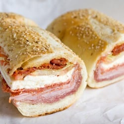 S & J Deli Superette - Fresh mozzarella,sundried tomatoes hot soppressata, ham and salami..on fresh bronx bread..Topped off with our own house dressing