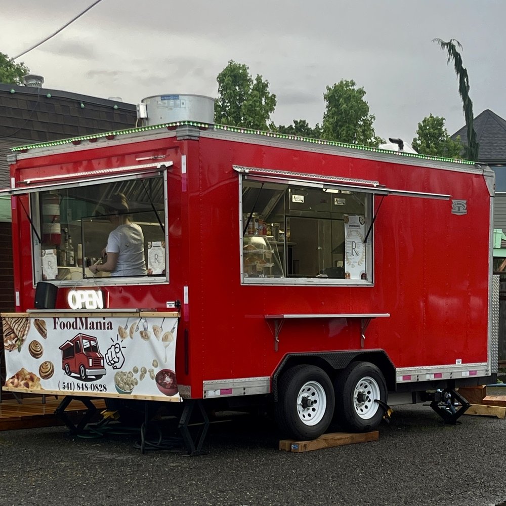 a red food truck parked in a parking lot a red food truck parked in a parking lot