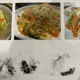 A plate of stir-fried noodles with vegetables, egg, and sauce, served on a white dish.