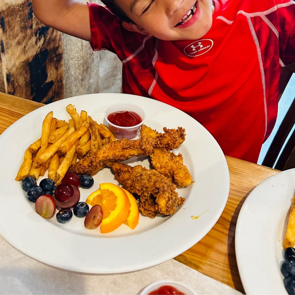 Rustic Table - Happy kid with their lunch. - Southern Near Me - Pawleys Island, South Carolina Rustic Table - Happy kid with their lunch. - Southern Near Me - Pawleys Island, South Carolina