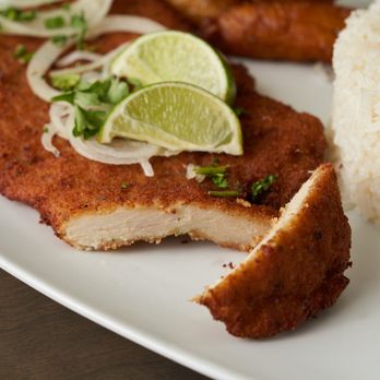 Latin Cafe 2000 - a plate of chicken with rice and lime wedges - Latin American Near Me - Hialeah, Florida