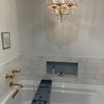 Kucera Construction - a bathroom with a tub and chandelier - General Contractors Near Me - Norridge, Illinois