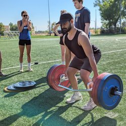 ONE Boulder Fitness - Members cheering each other on during outdoor deadlift training.
