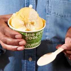 Ben & Jerry’s - Person holding Mango ice cream in a cup at a Ben & Jerry's ice cream shop. Mango is Mango Ice Cream Swirled with Sweet Cream ...