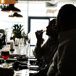 Fleisch - Two guests at the bar at Restaurant Fleisch in Copenhagen's Meatpacking District with drinks and candlelight.