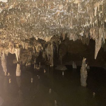 Meramec Caverns - Near the end of the cave with some water with a bunch of stalactites forming on the ceiling and the floor. - Tours Near Me - Sullivan, Missouri Meramec Caverns - Near the end of the cave with some water with a bunch of stalactites forming on the ceiling and the floor. - Tours Near Me - Sullivan, Missouri