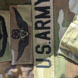 Misaligned badges and US ARMY double stitched.