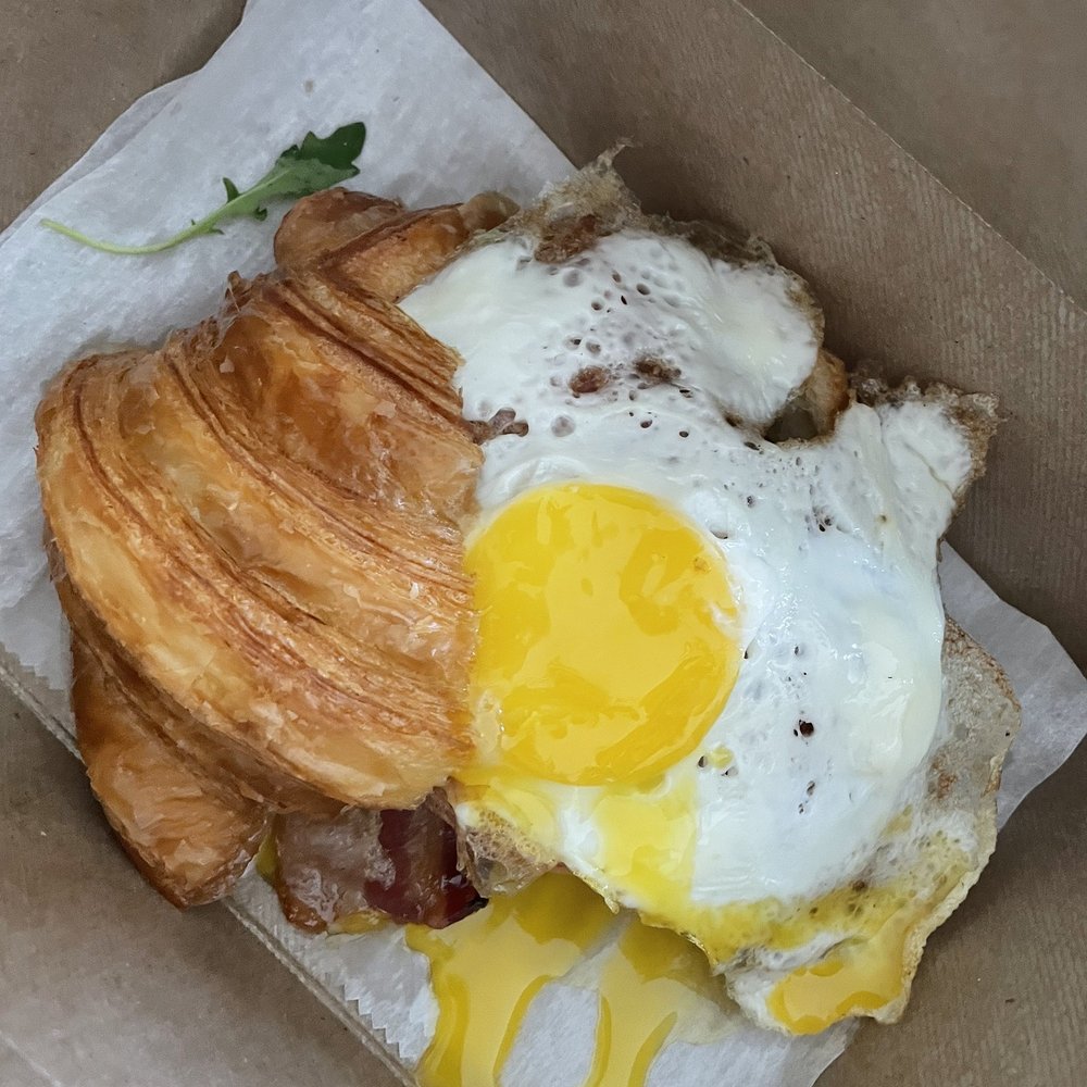 Tatte Bakery & Cafe | Assembly Row - Croissant Sandwich without arugula with added bacon - Breakfast & Brunch Near Me - Somerville, Massachusetts Tatte Bakery & Cafe | Assembly Row - Croissant Sandwich without arugula with added bacon - Breakfast & Brunch Near Me - Somerville, Massachusetts