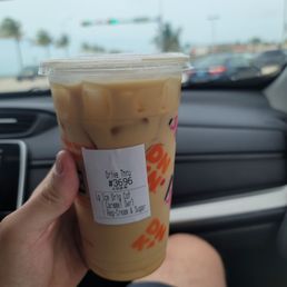 a hand holding a cup of iced coffee a hand holding a cup of iced coffee