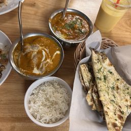 Bottom left vegetarian Veg. Butter Chicken and top right Mango Lassi and Paneer Butter Masala with Garlic Naan