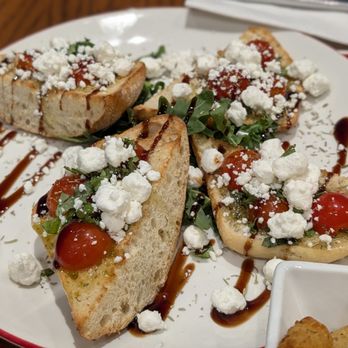 Vino Volo - Gate C1 - Tomato Bruschetta  Telera bread, tomato, basil, balsamic glaze, garlic oil, salt & pepper with Goat Cheese Crumbles - Wine Bars Near Me - Jacksonville, Florida