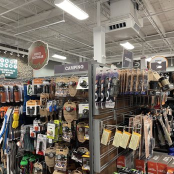 Sierra Poughkeepsie - Camping accessories - The image shows a store aisle with camping gear, outdoor accessories, and footwear, organized on shelves and racks. - Sporting Goods Near Me - Poughkeepsie, New York