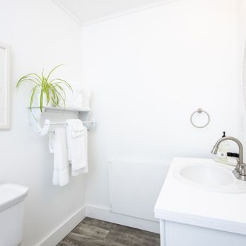 Western Inn - a bathroom with a toilet, sink, and mirror - Hotels Near Me - Callicoon, New York