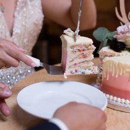a bride and groom cutting their wedding cake