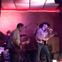 a band performing in a dimly lit room a band performing in a dimly lit room