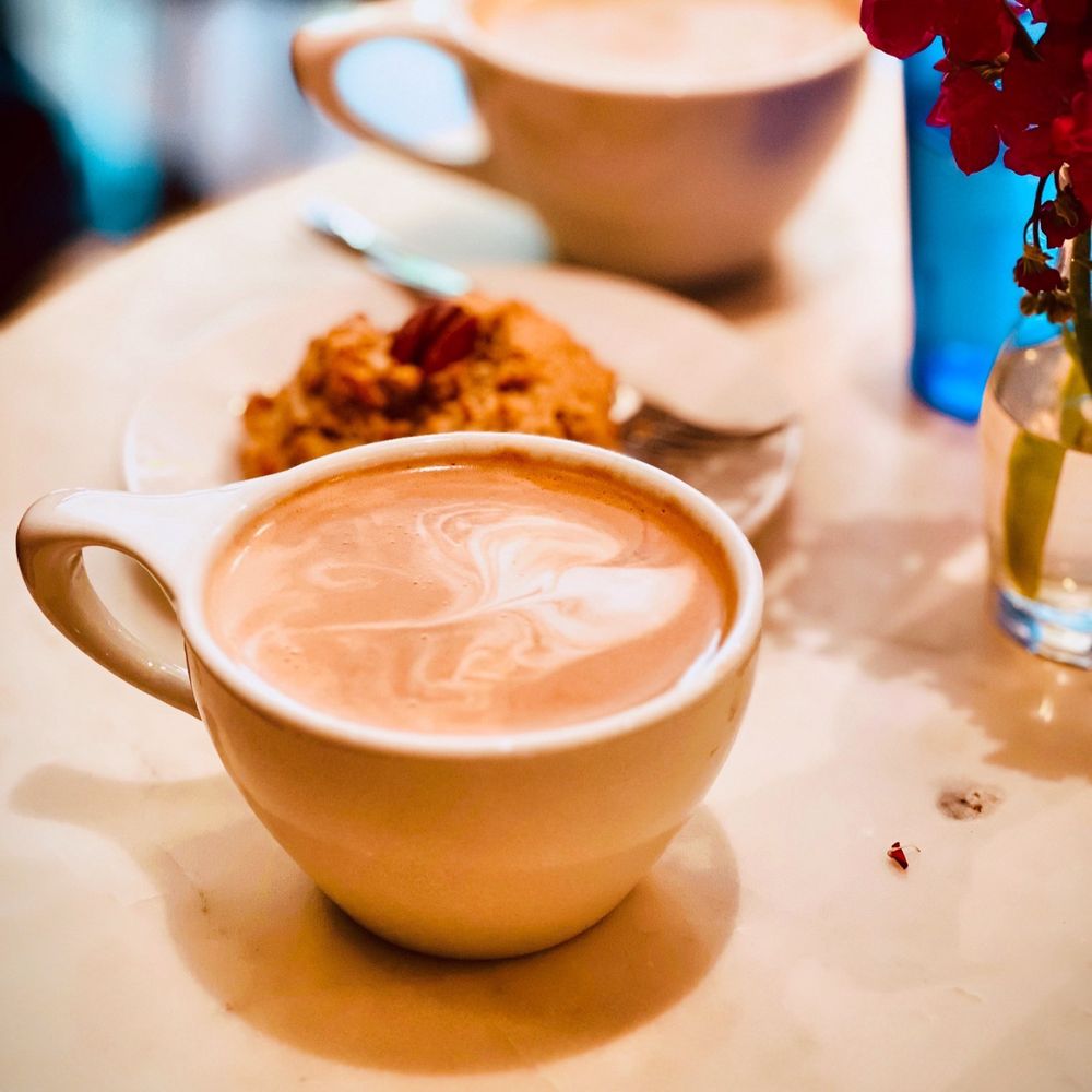 Americano with oat milk and a gluten free caramel pecan scone. Americano with oat milk and a gluten free caramel pecan scone.