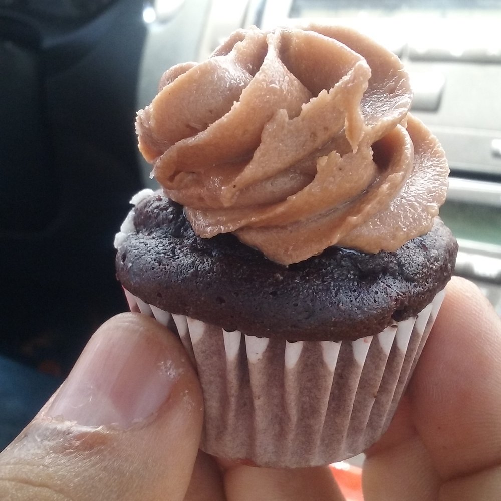 a hand holding a cupcake a hand holding a cupcake
