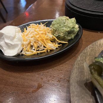Uncle Julio's - Sides of sour cream, cheese, guac that come with fajita - Mexican Near Me - Skokie, Illinois