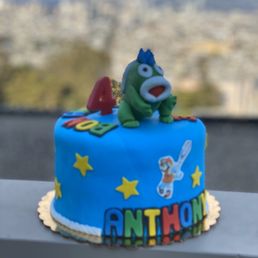 a blue cake with a cartoon character on top a blue cake with a cartoon character on top