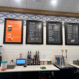 Menu - Four digital menu boards list various coffee, tea, and drink options at Summer Moon Coffee in Spring, TX.