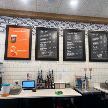 Summer Moon Coffee - Menu - Four digital menu boards list various coffee, tea, and drink options at Summer Moon Coffee in Spring, TX. - Coffee & Tea Near Me - Spring, Texas