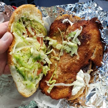 El Taco Azteca - a hand holding a sandwich - Mexican Near Me - Hyattsville, Maryland