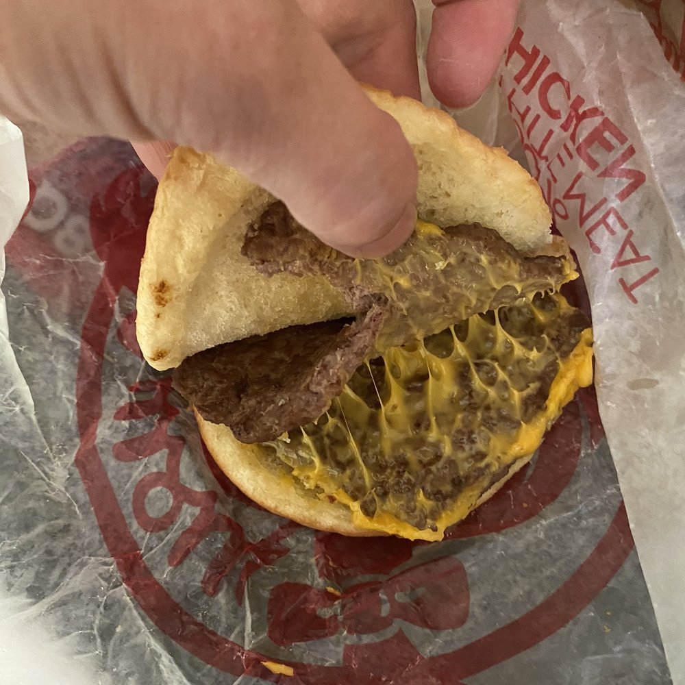 Wendy's - a hand grabbing a hamburger from a wrapper - Burgers Near Me - Clackamas, Oregon Wendy's - a hand grabbing a hamburger from a wrapper - Burgers Near Me - Clackamas, Oregon