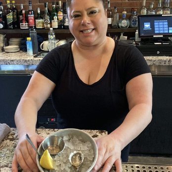 Taylor Shellfish Oyster Bar - Dawn serving up a Taylor family raised oyster with a champagne sauce. Delicious! - Seafood Near Me - Seattle, Washington