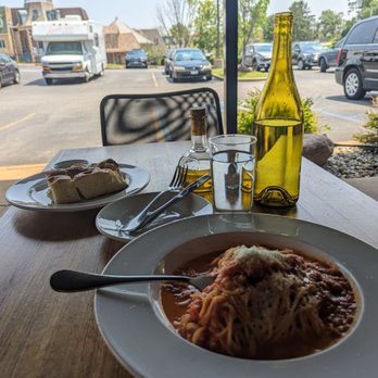 Sugo's Spaghetteria - a plate of spaghetti and a bottle of wine - Italian Near Me - Frontenac, Missouri