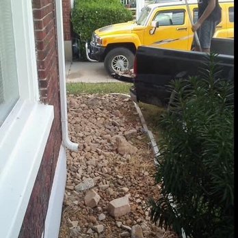 Yard Work Crew - a man standing on the side of a house - Landscaping Near Me