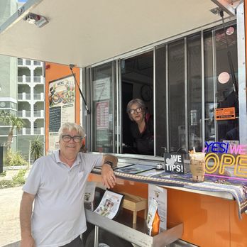 Coffee Caravan - The owners in the coffee truck with my drink on the side. - Juice Bars & Smoothies Near Me - Melbourne, Florida