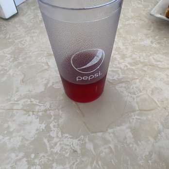 Upland Diner - Cranberry juice - A tall, frosted glass with a Pepsi logo contains a red drink, placed on a marble table in a casual setting. - Diners Near Me - Upland, Pennsylvania