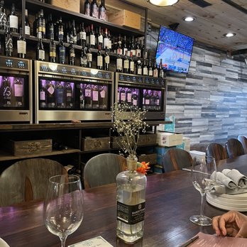 Ram Cat Cellars - Tables and wine wall - Whiskey Bars Near Me - Seneca, South Carolina
